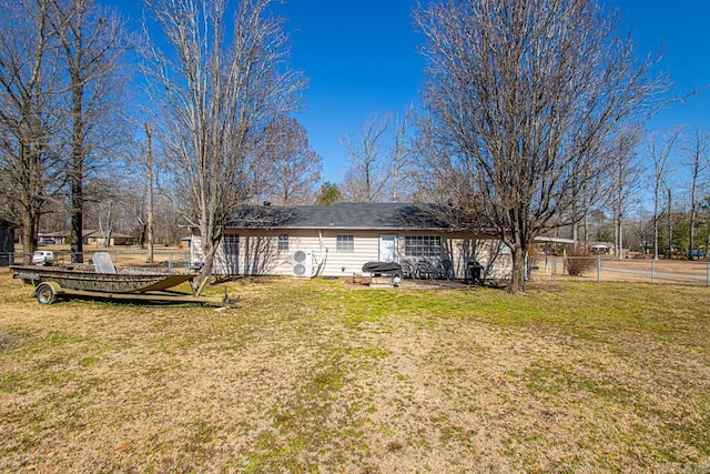 back of property featuring fence and a yard