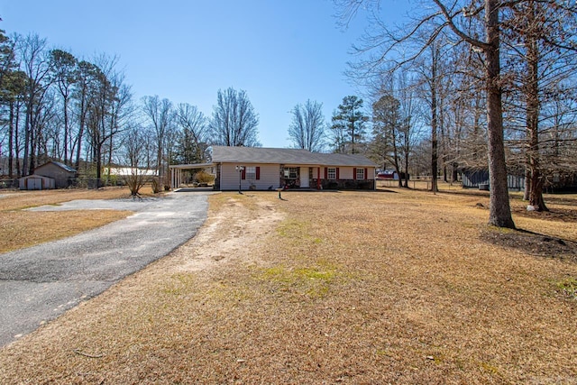 view of front of home featuring aphalt driveway and a front lawn