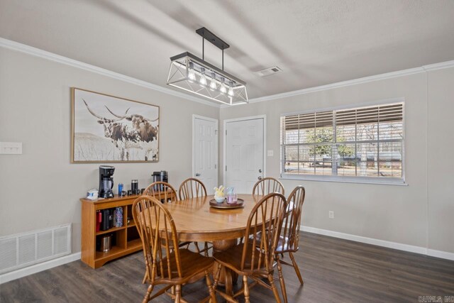 dining room featuring dark wood-style flooring, visible vents, crown molding, and baseboards