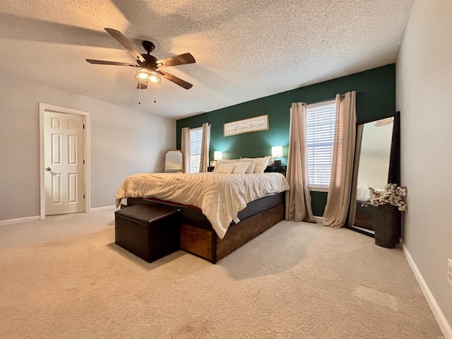 carpeted bedroom featuring ceiling fan, a textured ceiling, and baseboards