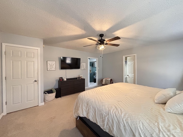 bedroom featuring light carpet, ceiling fan, and a textured ceiling