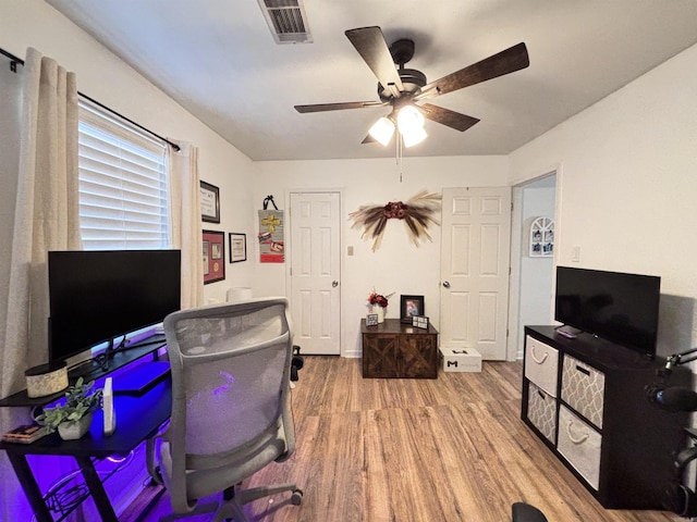 office space featuring wood finished floors, visible vents, and a ceiling fan