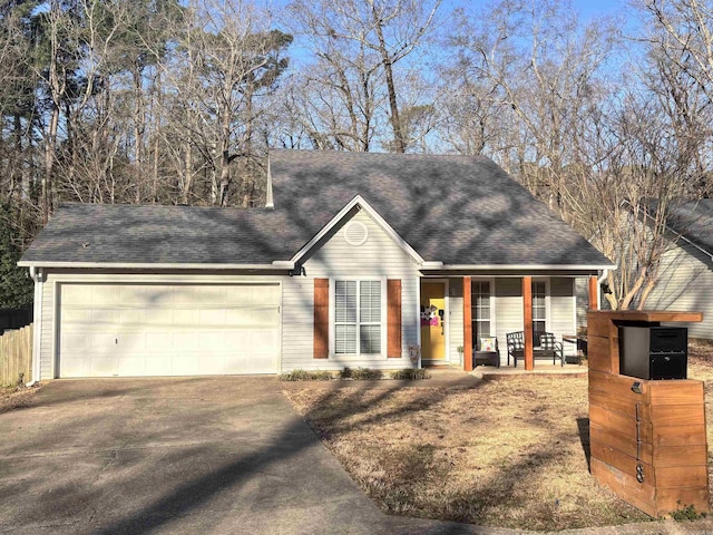 view of front of property with covered porch, driveway, roof with shingles, and an attached garage