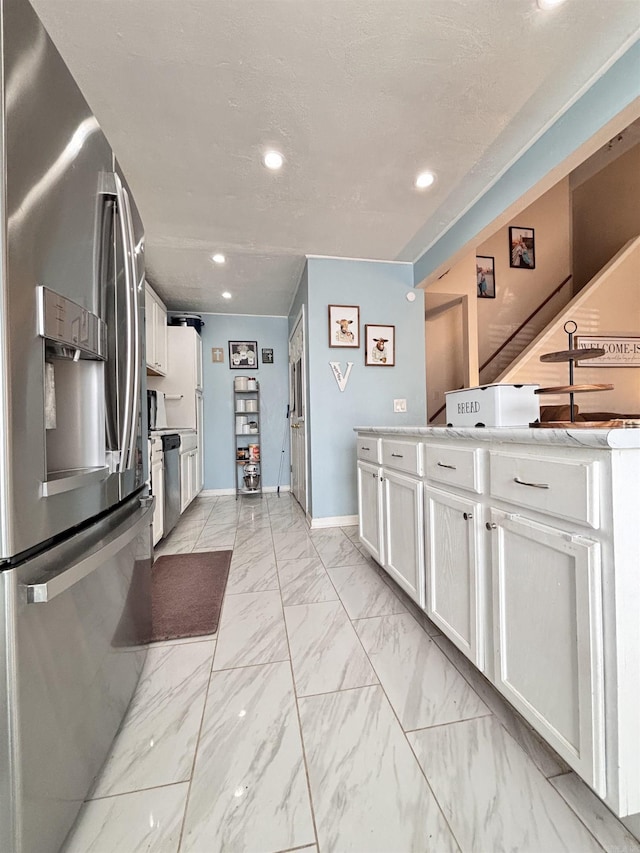 kitchen with stainless steel appliances, baseboards, white cabinets, marble finish floor, and light countertops