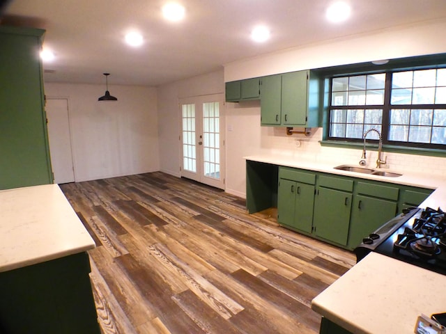 kitchen featuring green cabinetry, a sink, and light countertops