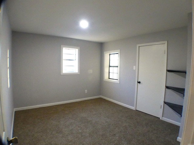 carpeted empty room featuring baseboards