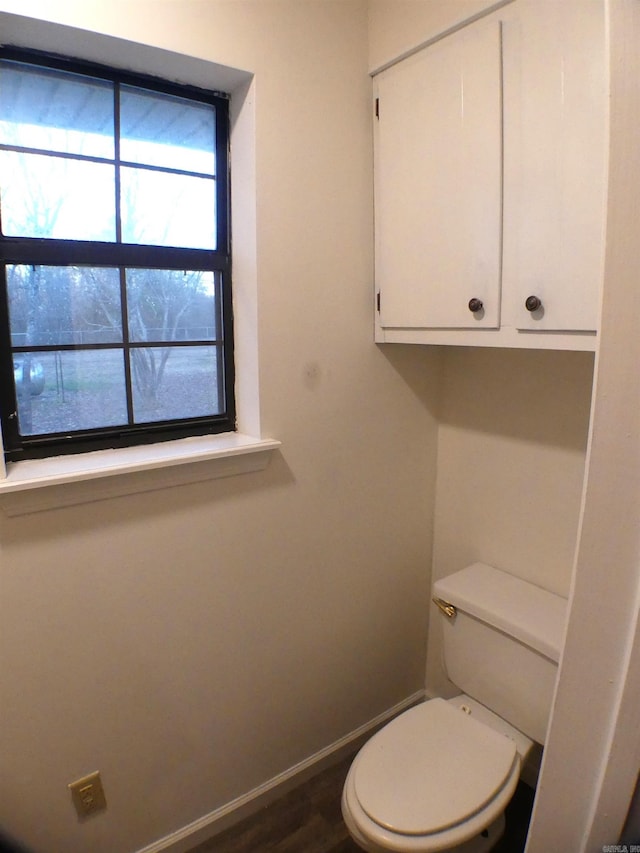 bathroom with wood finished floors, toilet, and baseboards