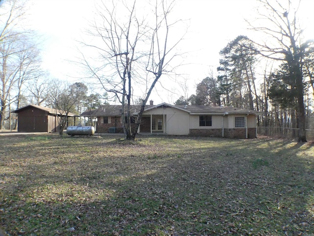 view of front facade with an outbuilding, a front yard, and fence