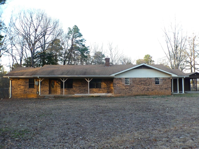 rear view of property featuring brick siding and a chimney