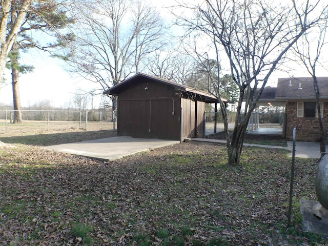 view of outdoor structure featuring fence and an outbuilding