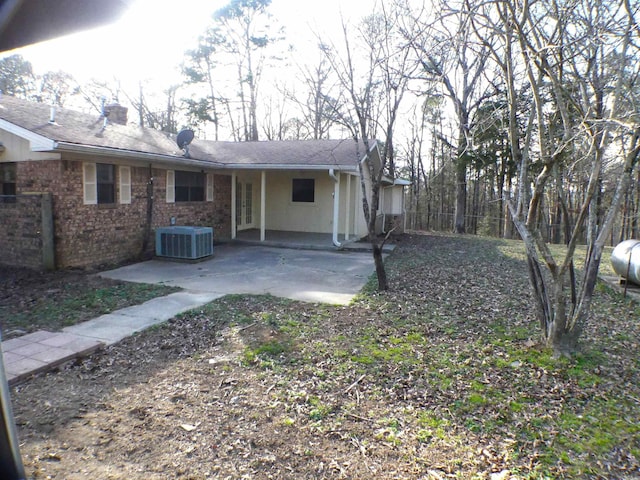 rear view of property with a patio area, a chimney, and central AC unit