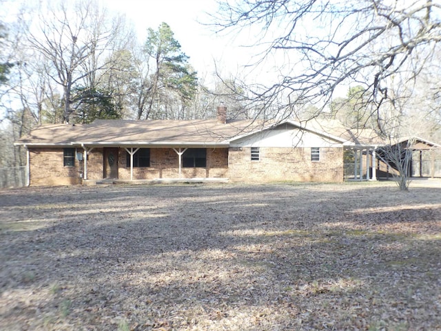 view of front facade featuring a chimney and brick siding