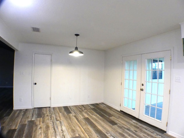 unfurnished dining area featuring french doors, visible vents, baseboards, and wood finished floors