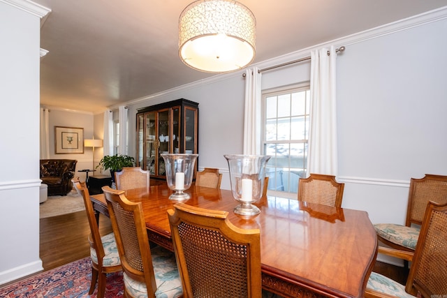 dining room with ornamental molding and dark wood-type flooring