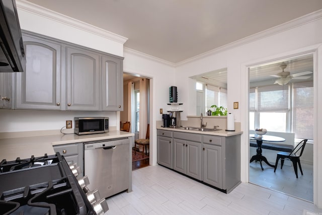 kitchen featuring light countertops, appliances with stainless steel finishes, gray cabinets, and a sink