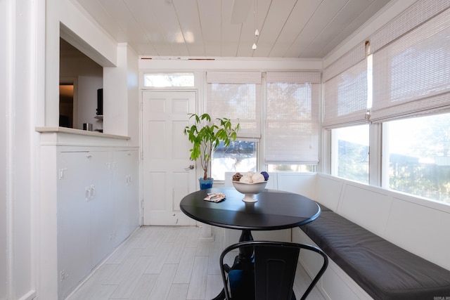 dining space with light wood-type flooring, wooden ceiling, and crown molding