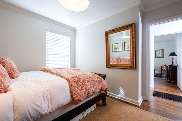 bedroom featuring dark wood-style floors, visible vents, baseboards, and crown molding