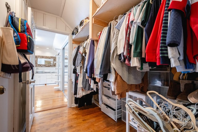 spacious closet with light wood-type flooring and lofted ceiling