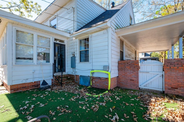 entrance to property featuring a lawn and a gate