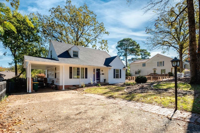 view of front facade featuring an attached carport, a shingled roof, fence, driveway, and crawl space