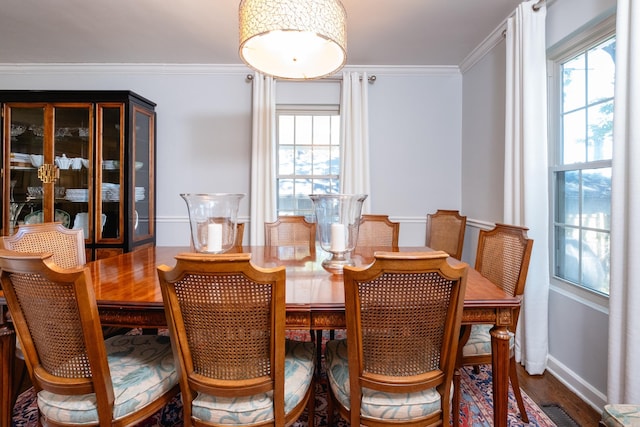 dining room with plenty of natural light, visible vents, ornamental molding, and wood finished floors