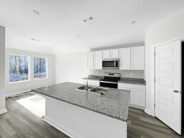 kitchen with appliances with stainless steel finishes, an island with sink, and white cabinets