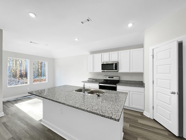 kitchen featuring appliances with stainless steel finishes, white cabinets, a kitchen island with sink, and visible vents