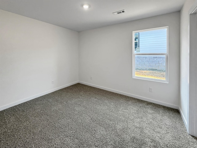 unfurnished room featuring carpet, visible vents, and baseboards