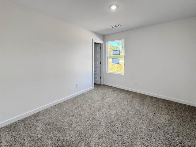 carpeted spare room featuring baseboards and visible vents