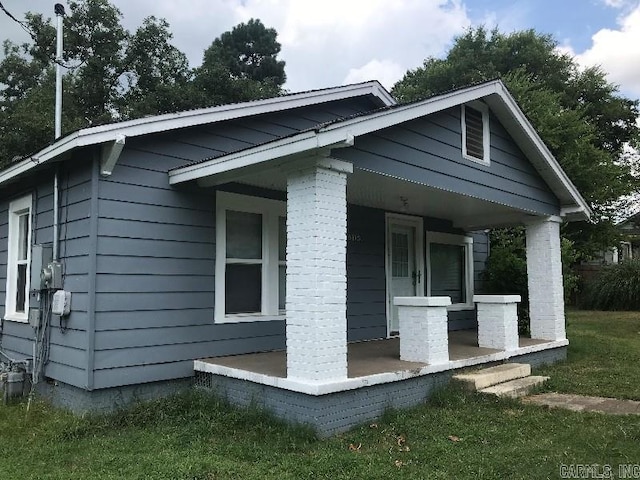 view of side of home featuring covered porch