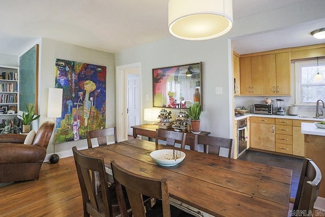 dining area with dark wood-style floors and a toaster