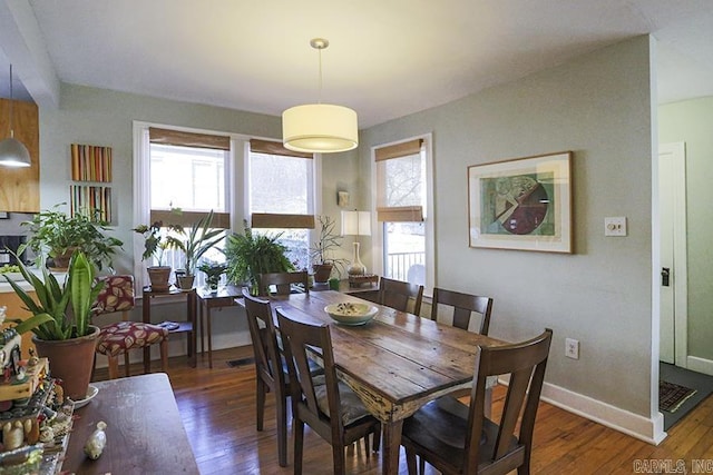 dining area featuring baseboards and dark wood finished floors