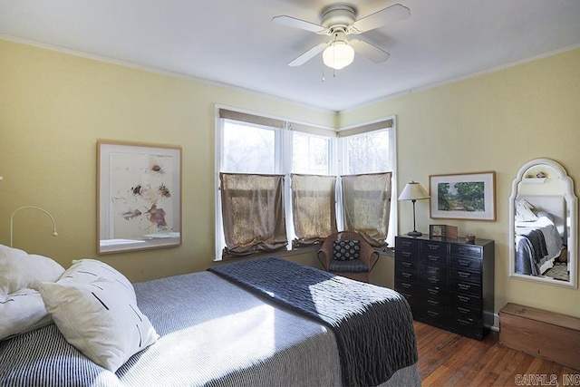 bedroom with dark wood-type flooring, crown molding, and ceiling fan