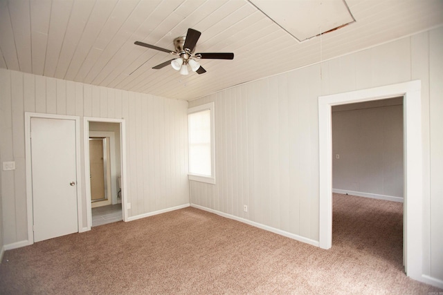 unfurnished bedroom featuring wooden ceiling, attic access, connected bathroom, and carpet flooring