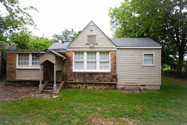 view of front facade featuring crawl space, roof with shingles, and a front yard