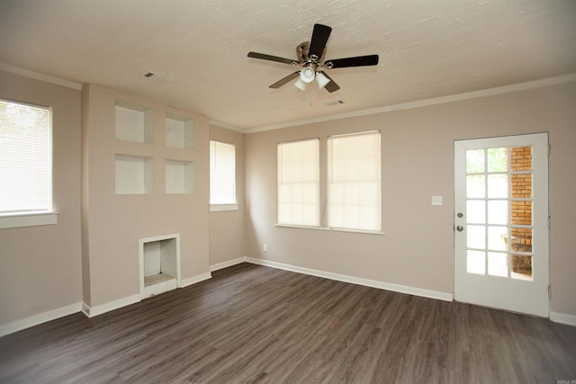 unfurnished living room with dark wood-style floors, a fireplace, crown molding, visible vents, and baseboards