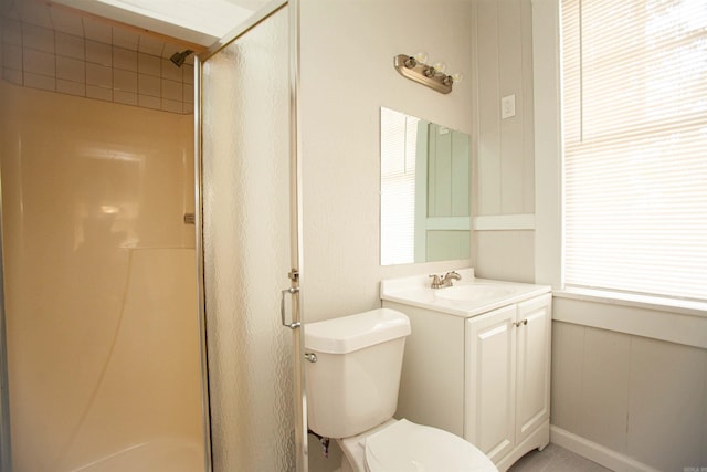 bathroom with a stall shower, vanity, and toilet