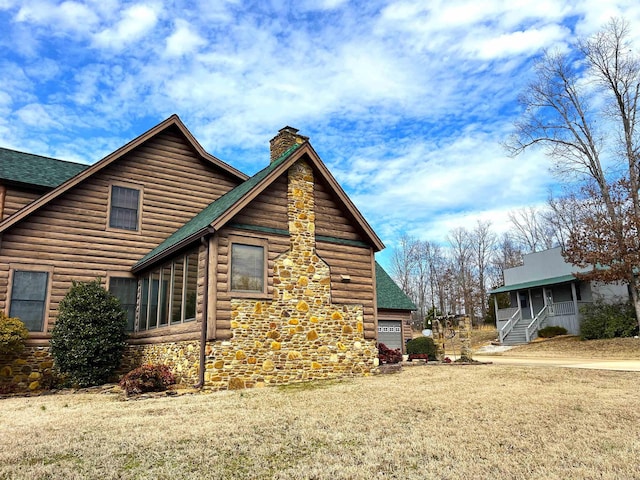 view of home's exterior with stone siding, a shingled roof, a chimney, and a yard