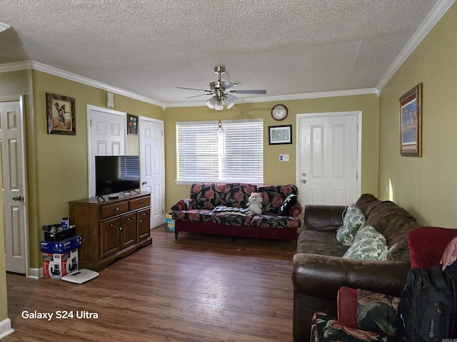 living area featuring a textured ceiling, ornamental molding, dark wood finished floors, and a ceiling fan