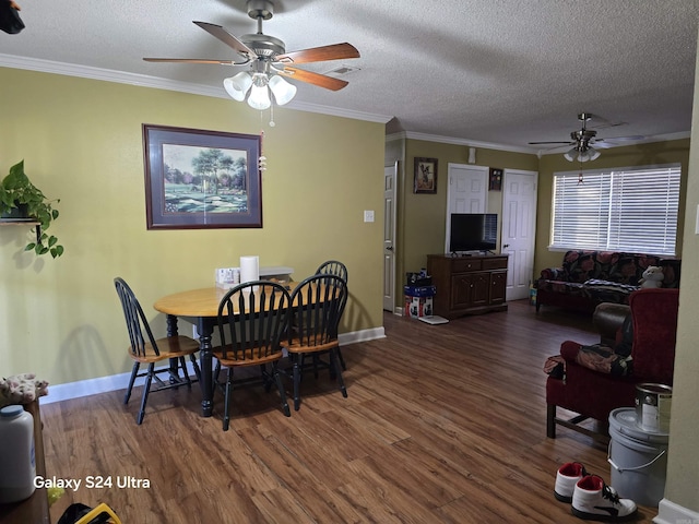 dining area featuring dark wood-style floors, ornamental molding, a textured ceiling, and a ceiling fan