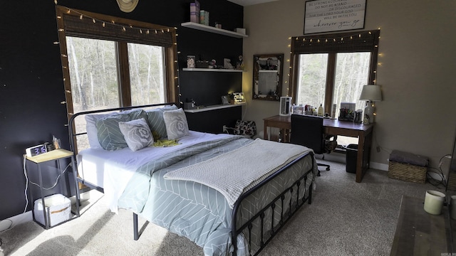 carpeted bedroom featuring multiple windows and baseboards