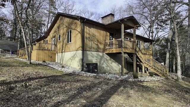 view of home's exterior with central AC unit, a chimney, and stairway