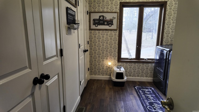 interior space featuring wood finished floors, visible vents, baseboards, and wallpapered walls