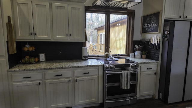 kitchen with appliances with stainless steel finishes, white cabinets, and a healthy amount of sunlight