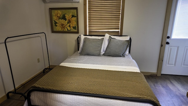 bedroom featuring a wall mounted air conditioner and wood finished floors