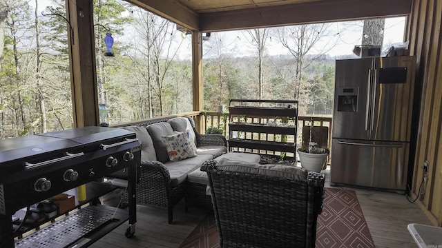 deck featuring a wooded view and an outdoor living space