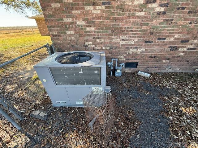 details featuring gas meter, central AC, and brick siding