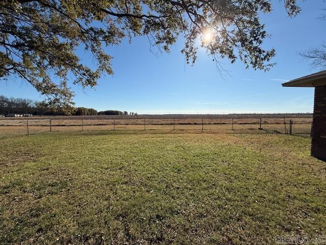 view of yard featuring fence and a rural view