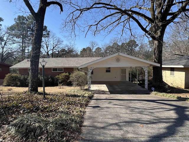 view of front of property with a carport, aphalt driveway, and brick siding