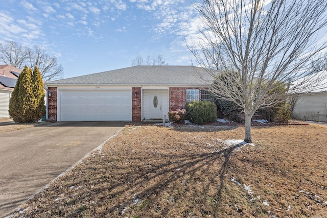 ranch-style home featuring driveway, an attached garage, roof with shingles, and brick siding